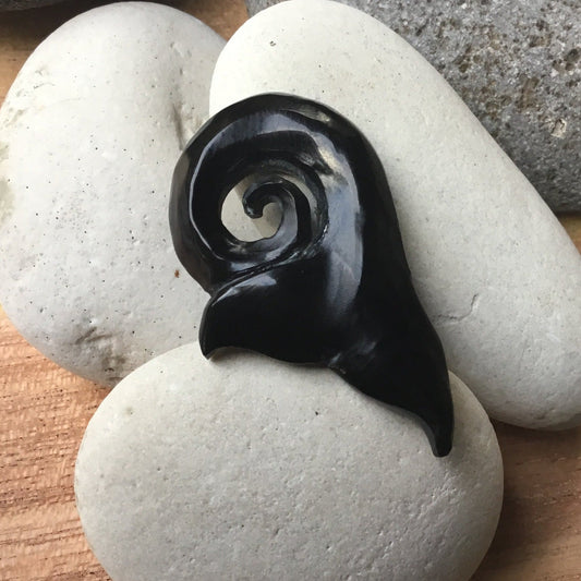 whale necklace, black. carved whale tail.