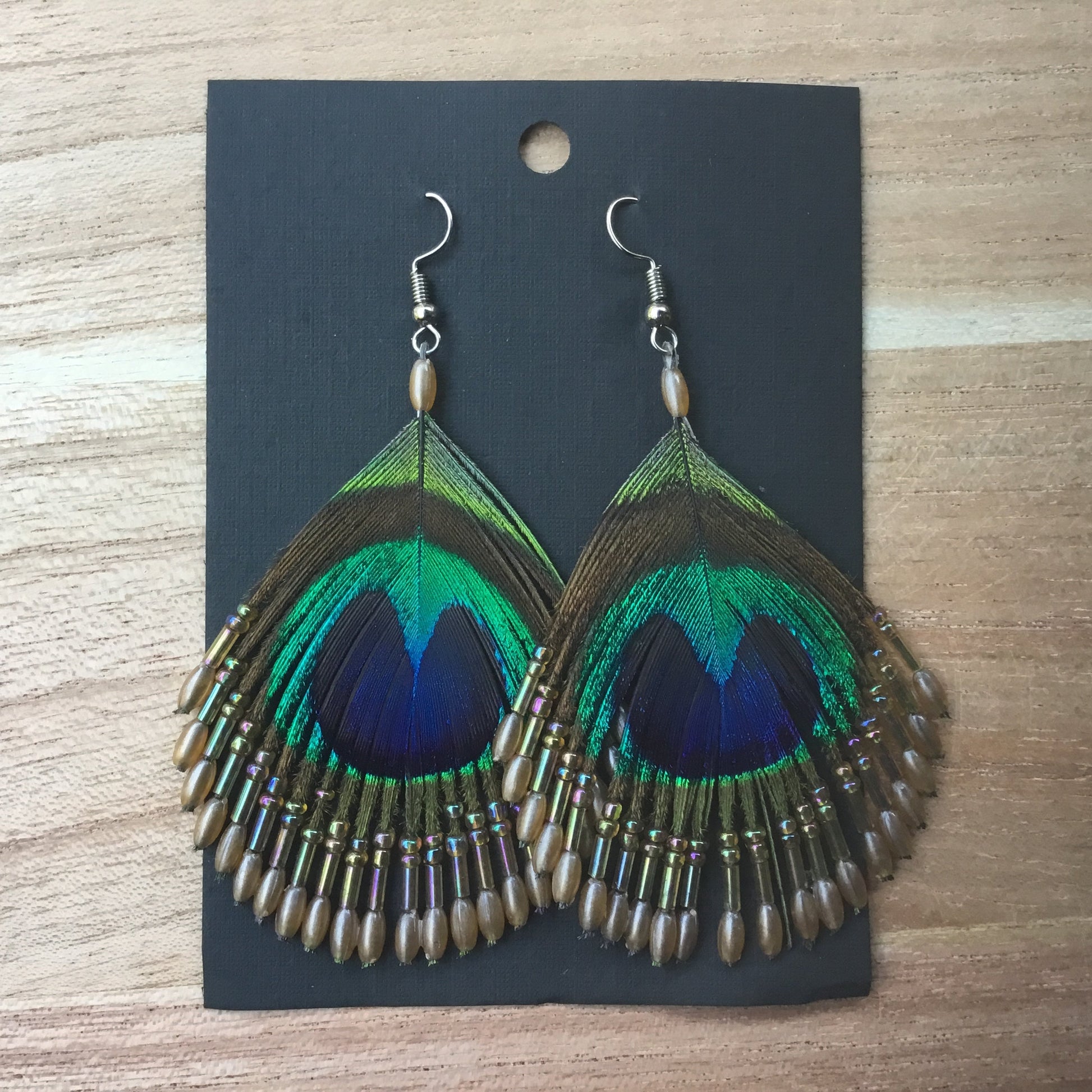 peacock feather earrings threaded with beads.