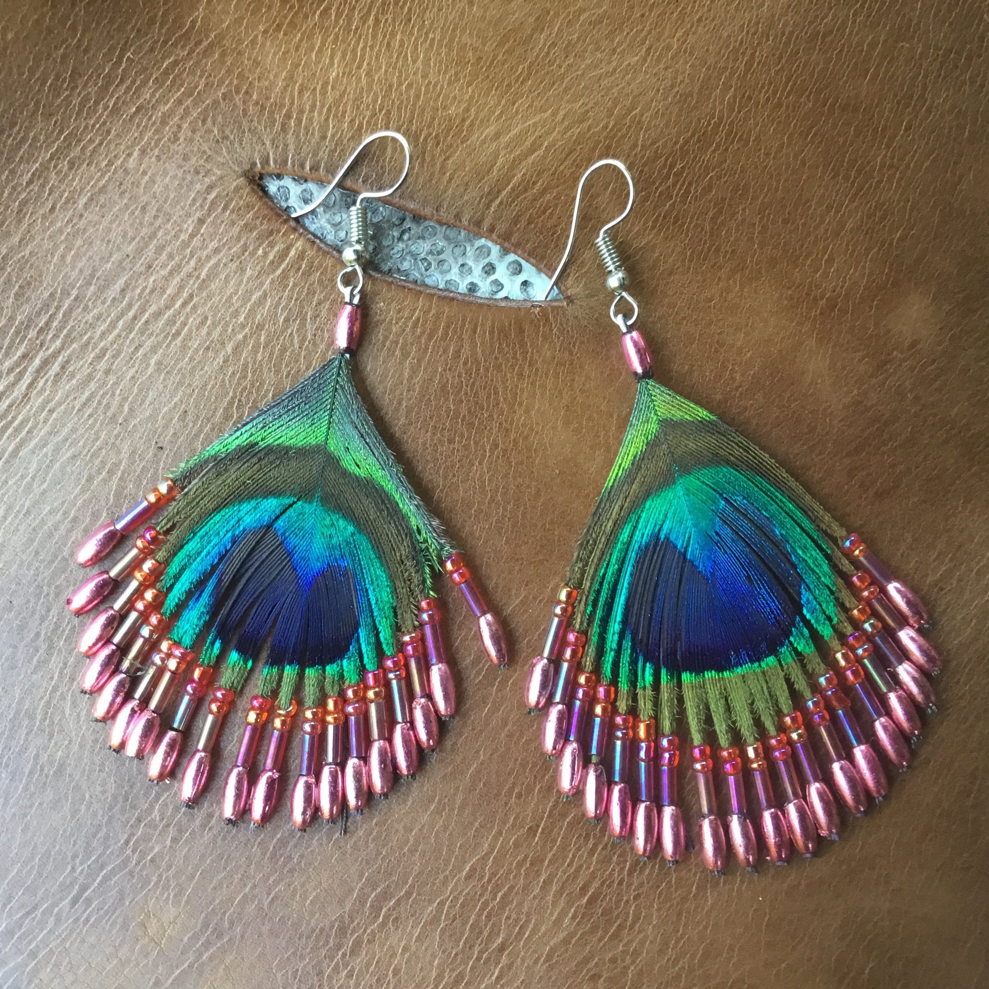 coral pink bead and peacock eye feather earrings.