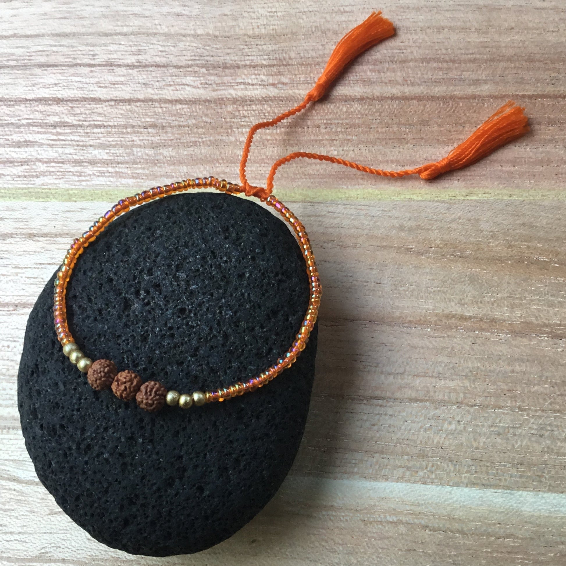 thin bead bracelet, adjustable. orange.