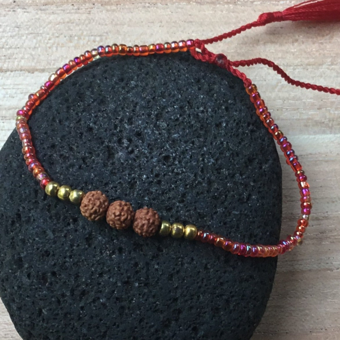thin red adjustable bead bracelet.